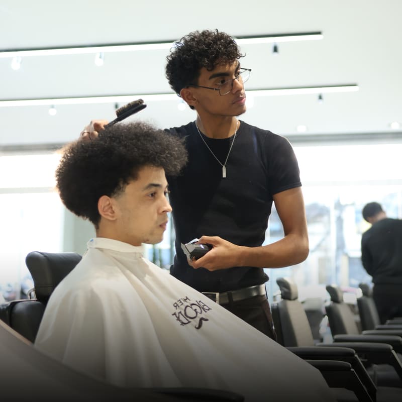 Barbeiro da Mister Bigode finalizando um corte na cadeira